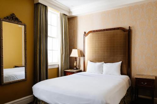 a hotel room with a large bed and a mirror at The Lafayette New Orleans by Kasa Living in New Orleans