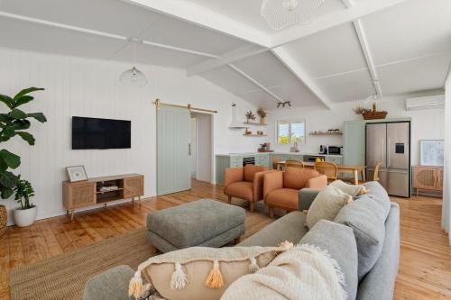 a living room with a couch and a table at Wine Down McLaren Vale, a cosy vineyard retreat in McLaren Vale