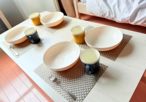 a table with four white plates and cups on it at 高平ハウス Room203 in Nagasaki