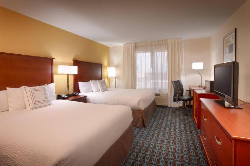 a hotel room with two beds and a flat screen tv at Fairfield Inn & Suites Boise Nampa in Nampa