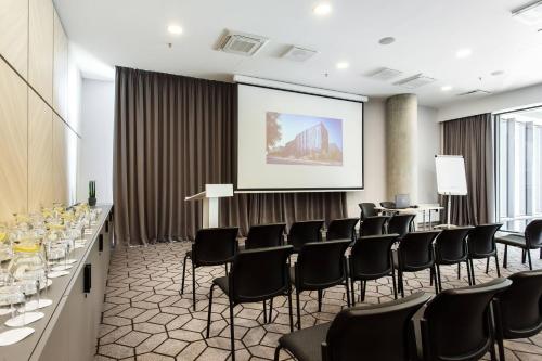 a conference room with chairs and a projection screen at Courtyard by Marriott Vilnius City Center in Vilnius