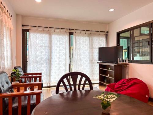 a living room with a table and a television at Cute House in Local Area, near CMU in Chiang Mai