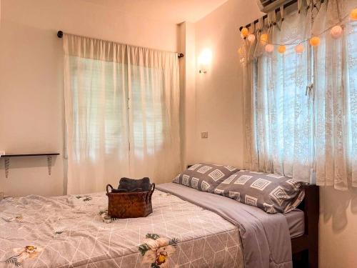 a bedroom with a bed with a basket on it at Cute House in Local Area, near CMU in Chiang Mai