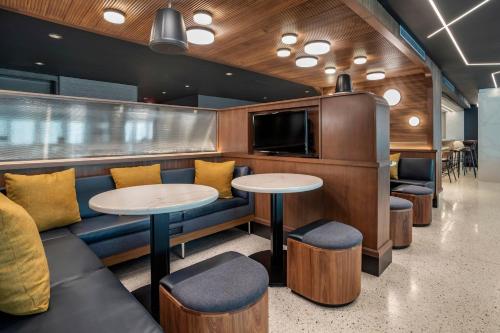 a restaurant with tables and chairs and a tv at Courtyard by Marriott Washington, DC Dupont Circle in Washington