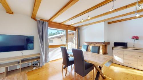 a dining room with a table and chairs and a tv at Abitaziun Pra d'Sura 133 - Maloja in Maloja