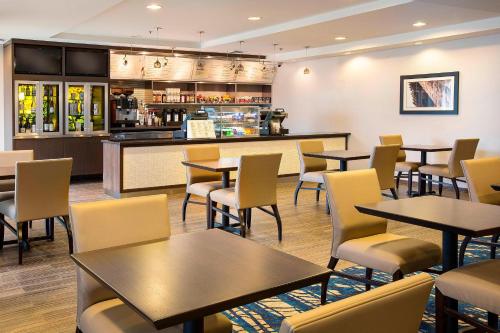 a restaurant with tables and chairs and a bar at Courtyard Seattle North / Lynnwood Everett in Lynnwood