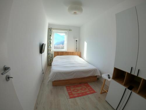 a small bedroom with a bed and a window at Panoramic Residence in Zărneşti