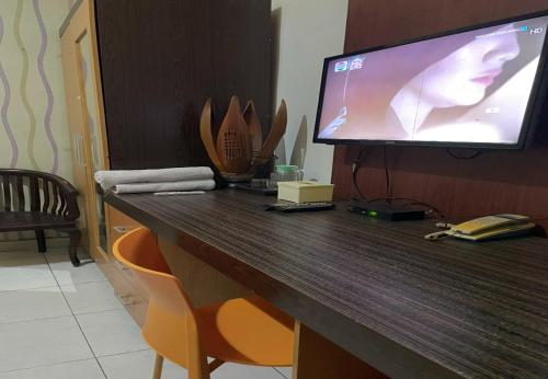 a desk with a television on top of it at Hotel Star 88 in Ngabean