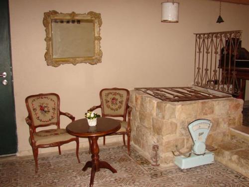 a living room with a stone fireplace and two chairs and a table at Boutique Agam Hahoresh - בוטיק אגם החורש in Haifa