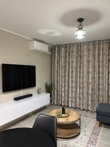 a living room with a tv and a table at Motswedi Place 1 Bed Apartment M10- Managed by Pulafela Prop Pty Ltd in Gaborone