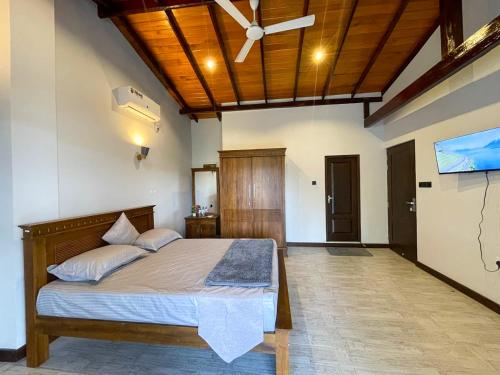 a bedroom with a bed with a ceiling fan at Lush Breeze in Kandy