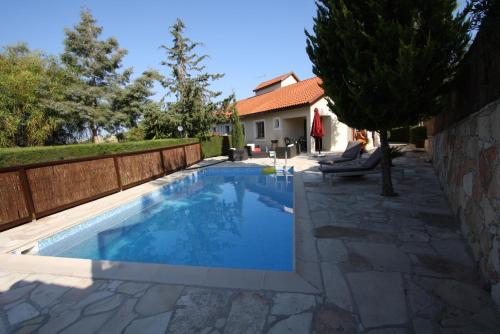 a swimming pool in a yard with a fence at Swimmers' Paradise in Pissouri