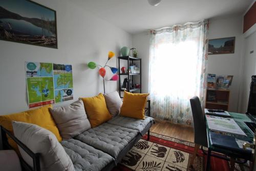 a living room with a couch with yellow pillows at O champ du lac in Saint-Pardoux