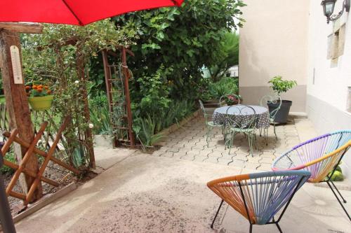 a patio with a table and chairs and an umbrella at O champ du lac in Saint-Pardoux