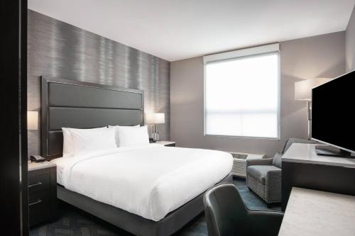 ein Hotelzimmer mit einem Bett und einem Fernseher in der Unterkunft Fairfield Inn & Suites by Marriott Boston Logan Airport/Chelsea in Chelsea