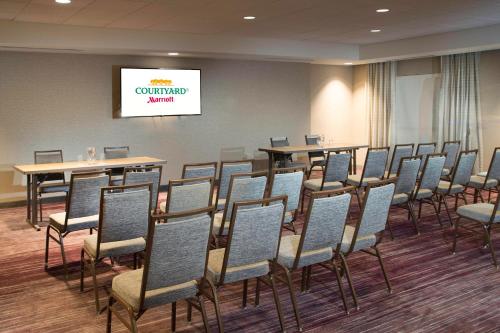 una sala conferenze con sedie, tavoli e schermo di Courtyard Largo Medical Center Drive a Largo