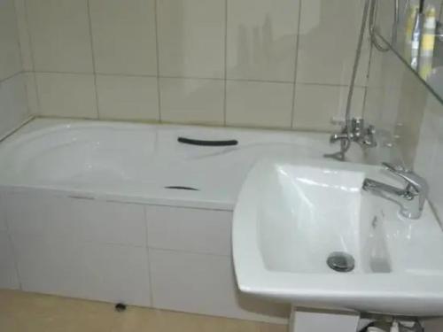 a bathroom with a sink and a bath tub at Cynergy Suites Royale - Standard in Lagos