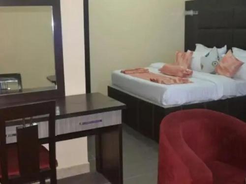 a bedroom with a desk and a bed with a mirror at Cynergy Suites Royale - Standard in Lagos