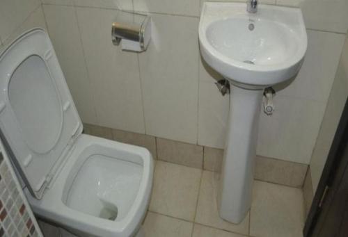 a bathroom with a toilet and a sink at Cynergy Suites Royale - Standard in Lagos