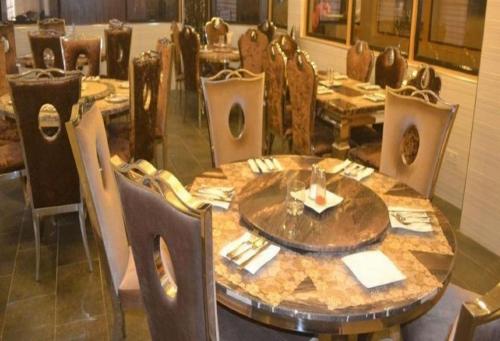 a dining room with a wooden table and chairs at Cynergy Suites Royale - Standard in Lagos
