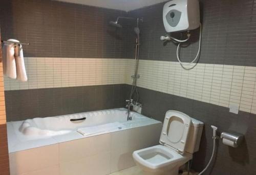 a bathroom with a tub and a toilet and a shower at Cynergy Suites Royale - Standard in Lagos