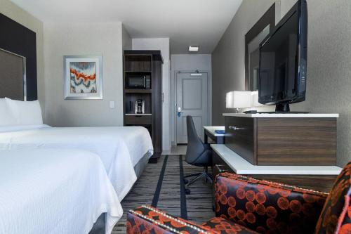 a hotel room with two beds and a flat screen tv at Fairfield Inn & Suites by Marriott Boston Cambridge in Cambridge