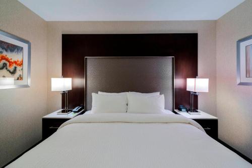 a large bed in a hotel room with two lamps at Fairfield Inn & Suites by Marriott Boston Cambridge in Cambridge