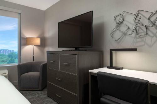 a hotel room with a television and a desk with a chair at Fairfield by Marriott Inn & Suites Boston Medford in Medford