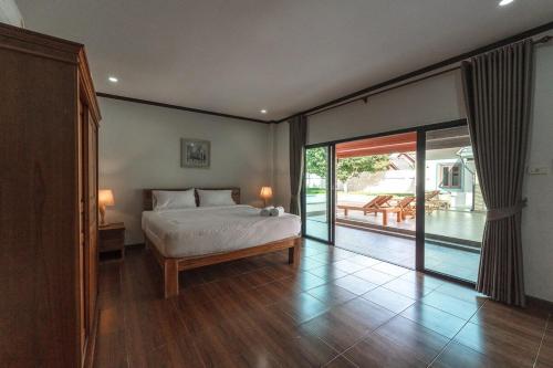 a bedroom with a bed and a sliding glass door at V155 4BR Large Family Villa Chalong in Chalong 