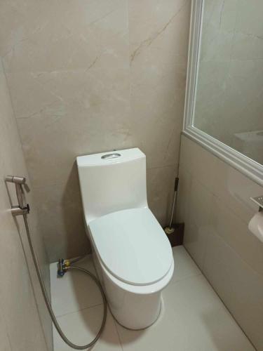 a bathroom with a white toilet and a shower at Skott's Comfy Lodge in Bantayan Island