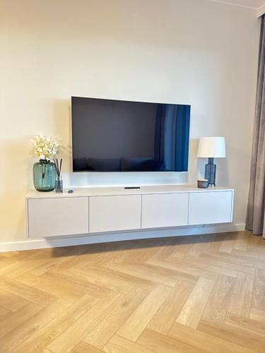 a living room with a television on a white entertainment center at Apartament Premium Zamkowa B12 in Tczew