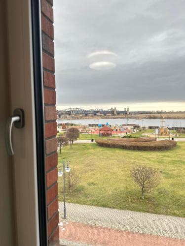 a window with a view of a field and a body of water at Apartament Premium Zamkowa B12 in Tczew