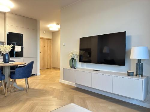 a living room with a large television on a wall at Apartament Premium Zamkowa B12 in Tczew