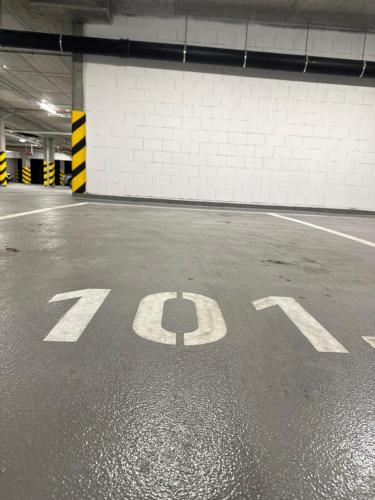 an empty parking garage with the number painted on the ground at Apartament Premium Zamkowa B12 in Tczew