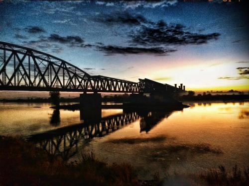 a train crossing a bridge over a body of water at Apartament Premium Zamkowa B12 in Tczew