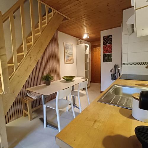 - une cuisine et une salle à manger avec une table et des escaliers dans l'établissement Between lake en ski resort, à Thollon-les-Mémises