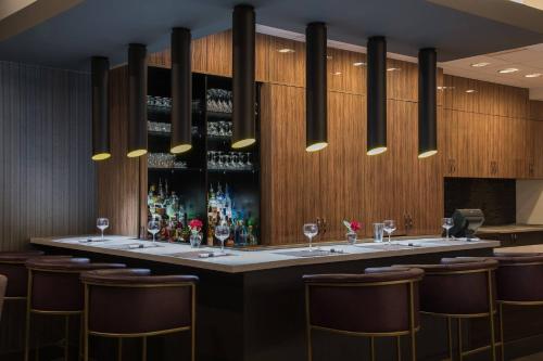 a bar in a restaurant with chairs and wine bottles at Courtyard by Marriott Bethesda Chevy Chase in Bethesda