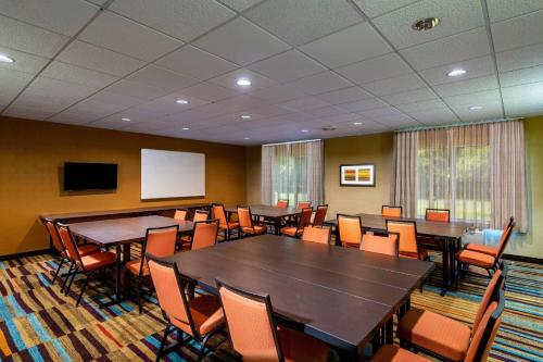 ein Konferenzraum mit Tischen und Stühlen und einer Leinwand in der Unterkunft Fairfield Inn Battle Creek in Battle Creek