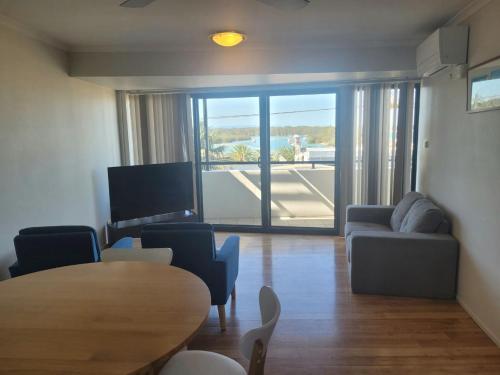 a living room with a table and chairs and a couch at Holiday In Husky - 2 Bedroom Apartment located in the centre of town in Huskisson
