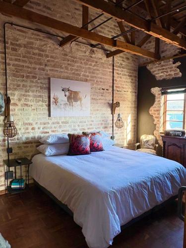 a bedroom with a large bed in a brick wall at Eccentric Heritage Paradise Simon's Town in Simonʼs Town