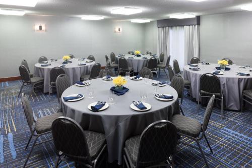 a conference room with round tables and chairs with flowers on them at Courtyard by Marriott Waco in Waco