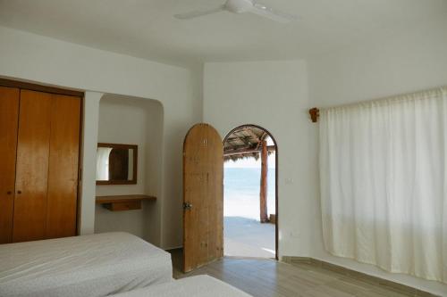 a bedroom with a bed and an open door to the ocean at Elysian Private Haven Ultimate Front Beach Paradise, Isla Blanca in Isla Blanca