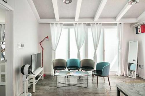 a living room with chairs and a table and a tv at Comfy & Cozy in Seoul