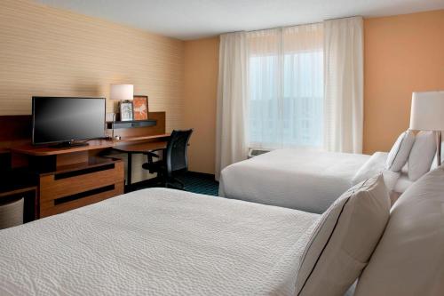 a hotel room with two beds and a desk with a computer at Fairfield Inn & Suites by Marriott Buffalo Amherst/University in Amherst
