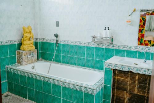 ウブドにあるWarsi Bungalowのバスルーム(バスタブ、像付)