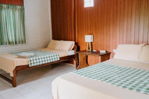 ウブドにあるWarsi Bungalowのベッドルーム1室(ベッド2台、ランプ付きテーブル付)