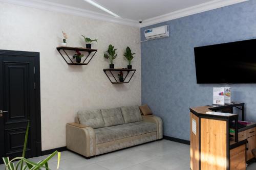 a living room with a couch and a flat screen tv at Samarkand Hostel in Samarkand