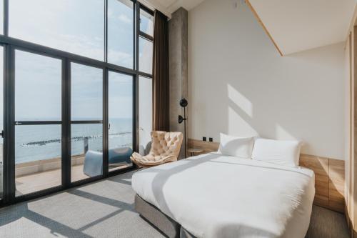 a bedroom with a bed and a large window at Adagio Dapeng Bay in Donggang