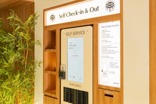 a sign that says self check in and out at 스테이 패스포트 후쿠오카 료칸 대전 유성점 in Daejeon