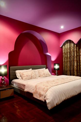 a bedroom with a large bed with a pink wall at maross bed and room in Chiang Mai